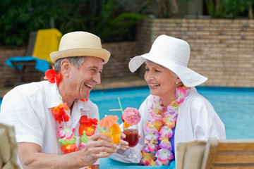 Wall Mural - Happy senior couple drinking cocktails and toasting each other