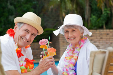 Happy senior couple drinking cocktails and toasting each other