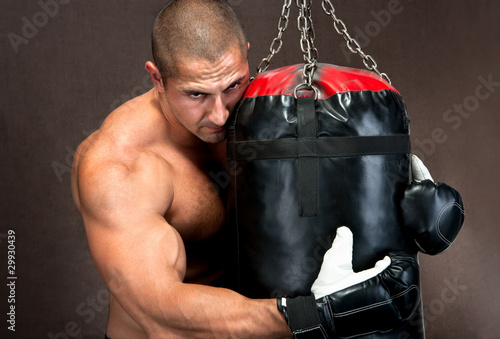 Board z aluminiowym obramowaniem Athletic młody człowiek szkolenia kickboxing za pomocą czarnej worek treningowy