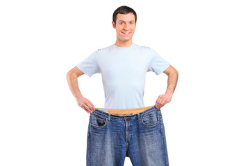 Portrait of a weight loss male showing his old jeans