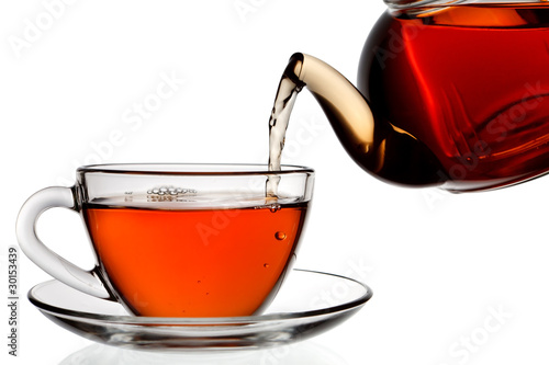 Fotografie, Obraz Tea being poured into glass tea cup isolated on a white backgrou