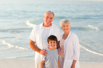 Wall Mural - Grandparents with his grandson at the beach