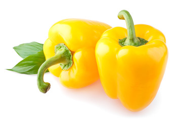 Two yellow sweet pepper with leaves isolated on white