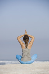 Wall Mural - Beautiful young woman with arms open, relaxing on the beach