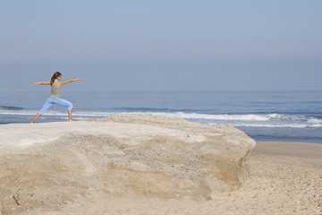 Wall Mural - Beautiful young woman with arms open, relaxing on the beach