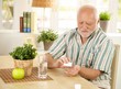 © nyul - Elderly man taking pill at home