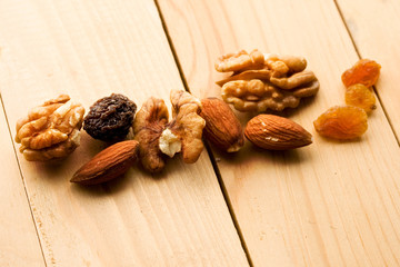 Wall Mural - Nuts and raisins isolated on wooden background