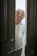 Annoyed senior woman answering front door