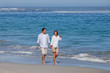 © WavebreakMediaMicro - Couple walking on the beach under the sun