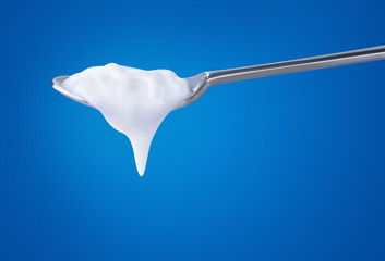 Poster - Spoon with natural yoghurt over blue background, with clipping path
