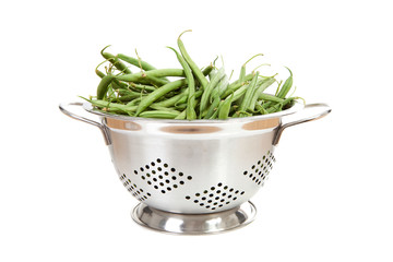 metal Colander with long green beans over white background