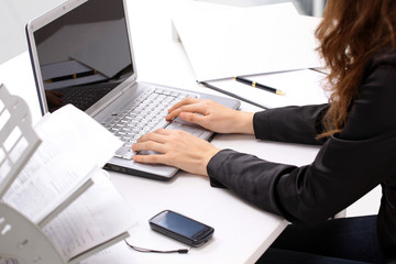 Wall Mural - Female hands typing on a keyboard and holding mouse