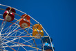 Multi-colored ferris wheel against a blue sky