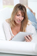 © goodluz - Blond woman using electronic tablet at home