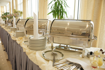 Wall Mural - Table with dishware and shiny marmites