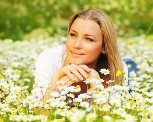 Wall Mural - Beautiful female laying on the flower filed