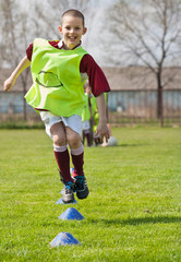 Wall Mural - boy jumping on the soccer field