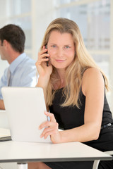  Businesswoman working in office with electronic tablet