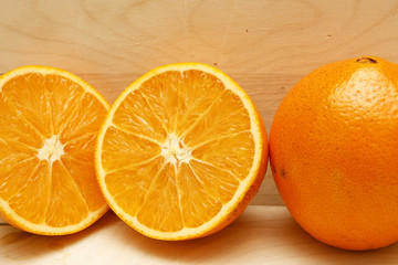 Whole and Two Half Oranges on Wood