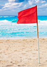 Red Warning Flag On A Stormy Beach