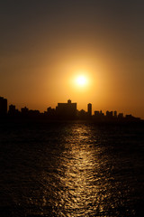 Wall Mural - The sun setting over Havana with a silhouetted view of the city