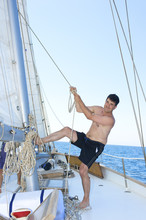 Mature Man Smiling While Hoisting The Sail