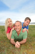 © goodluz - Portrait of happy family laying in grass