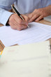 © goodluz - Closeup of senior man filling in tax form