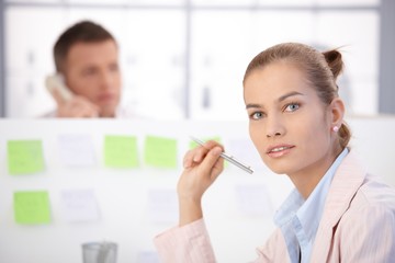 Canvas Print - Pretty female office worker sitting at desk