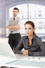 Wall Mural - Portrait of young businesswoman sitting at desk