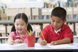© Monkey Business - Kindergarten children sitting at desk and writing in classroom