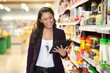 © Tyler Olson - Woman looking at digital tablet in shopping store