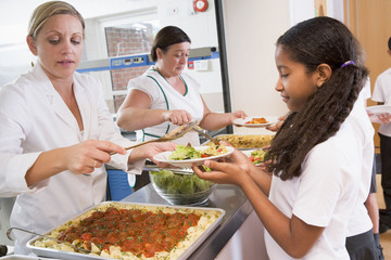 schoolgirl holding plate of lunch in school cafeteria