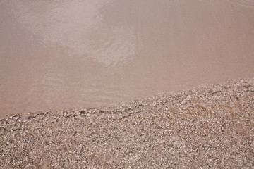 Wall Mural - Ripple water to the sand beach background texture