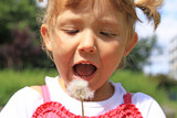 Fototapeta  - Girl blowing a dandelion