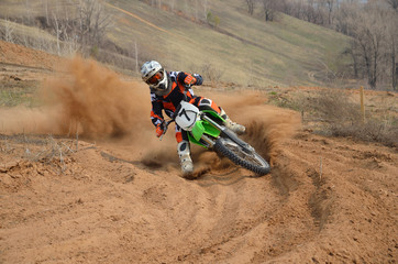 Fotobehang - motocross rider with a strong slope turns sharply