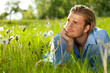 junger mann liegt im gras und relaxt
