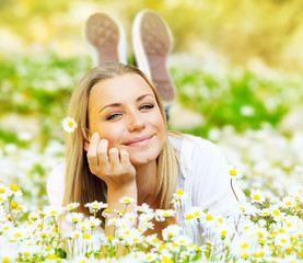 Wall Mural - Beautiful female laying on the flower filed