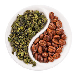 Wall Mural - Green leaf tea versus coffee beans in Yin Yang shaped plate, iso