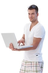 Wall Mural - Young man using laptop smiling