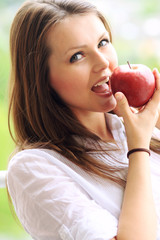 Wall Mural - Beautiful smiling woman holding apple