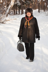 Wall Mural - mature woman is walking in winter