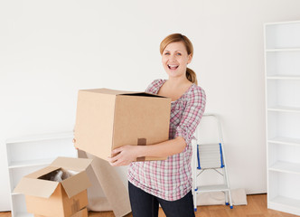 Wall Mural - Smiling woman carrying cardboard boxes