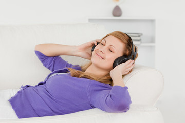 Wall Mural - Good looking red-haired woman listening to music and enjoying th