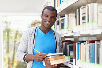 young african man smiling in library