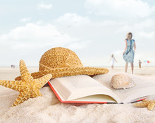 Straw Hat , Book And Seashells In The Sand