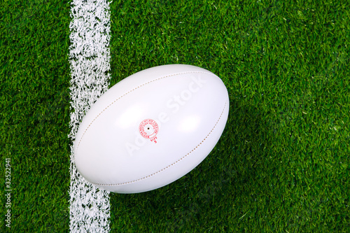 Plakat na papierze fotorealistycznym Piłka do rugby na trawie z góry.