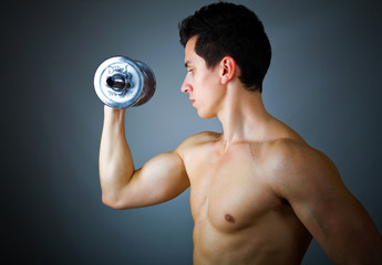 Fitness - powerful muscular man lifting weights