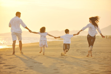 happy young family have fun on beach at sunset