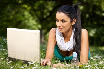 Pretty girl browsing internet in citypark